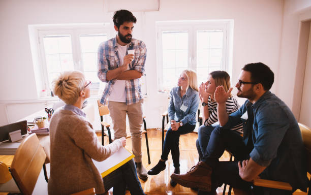 istock Young people with problems listening to their nervous friend confession while sitting together on special group therapy. 941282196