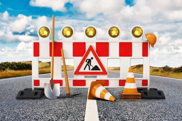 Street barrier with shovel, traffic sign, traffic cone and safety helmet on the road 3D rendering