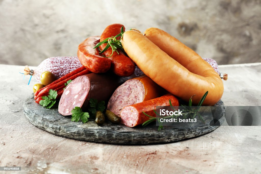 Food tray with delicious salami, ham,  fresh sausages, cucumber and herbs. Meat platter Food tray with delicious salami, ham,  fresh sausages, cucumber and herbs. Meat platter with selection Sausage Stock Photo