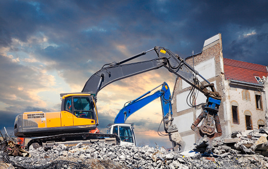 Bulldozers demolishing old house at construction site