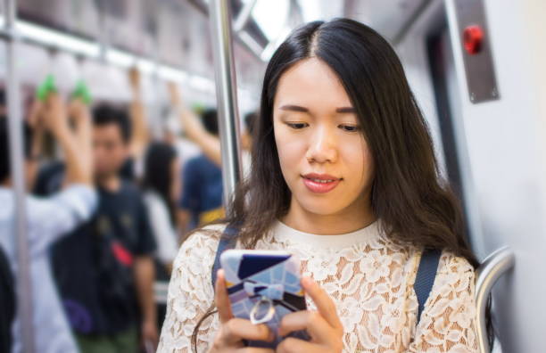 istock Asian girl using phone on subway 941298196
