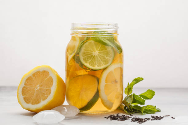 istock Lemon lime ice tea with mint in a glass jar, white background, copy space. Summer refreshing drink concept. 941298984