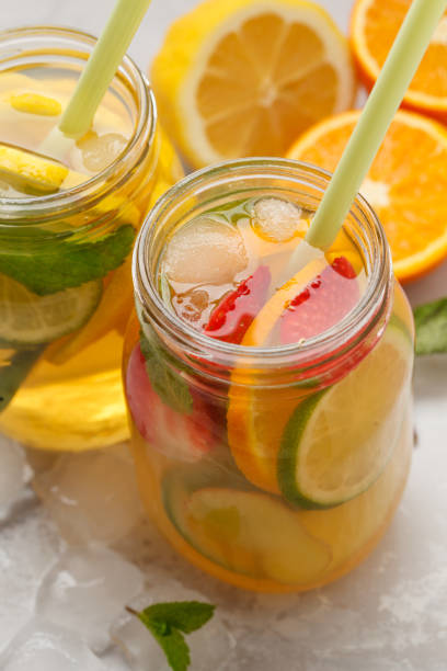 istock Fruit ice tea and ginger herbal ice tea with mint in glass jars, white background, copy space. Summer refreshing drink concept. 941299814