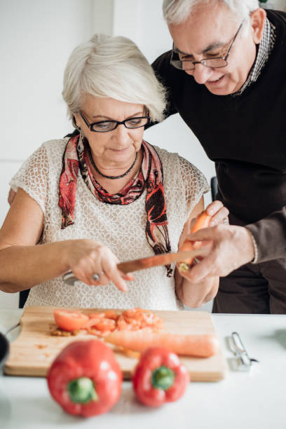 istock Senior husband helping his wife in the kitchen 941300098