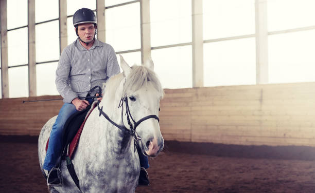 istock People on a horse training in a wooden arena 941303330
