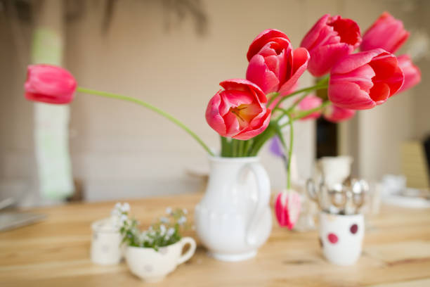 istock Beautiful table setting with red tulips, forget-me-not and cups on the wooden table. 941303684