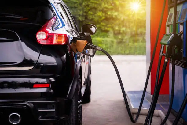Pumping gasoline fuel in car at gas station,travel,transportation and holiday concept.