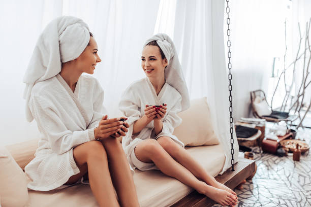 mujeres jóvenes en el salón de spa - bathrobe women cup towel fotografías e imágenes de stock