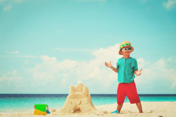 istock little boy building sand castle on beach 941310360