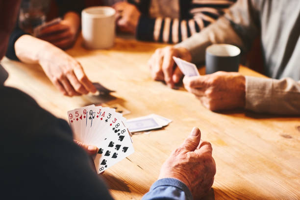 personas mayores jugando a las cartas - game cards fotografías e imágenes de stock