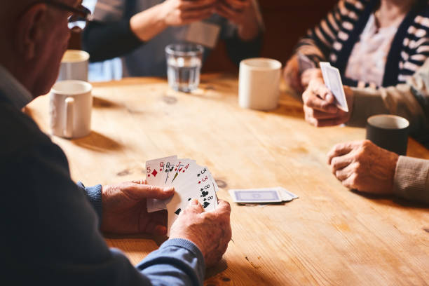 istock Elder man playing cards with friends 941321132