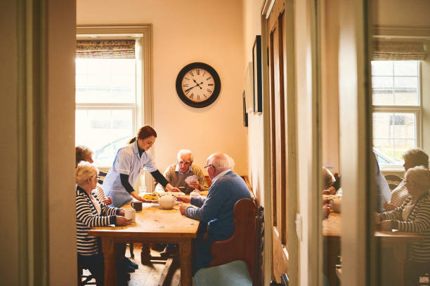 요양원에서 고위 사람들에 게 음식을 제공 하는 ��여성 간호사 - group of people aging process home interior indoors 뉴스 사진 이미지