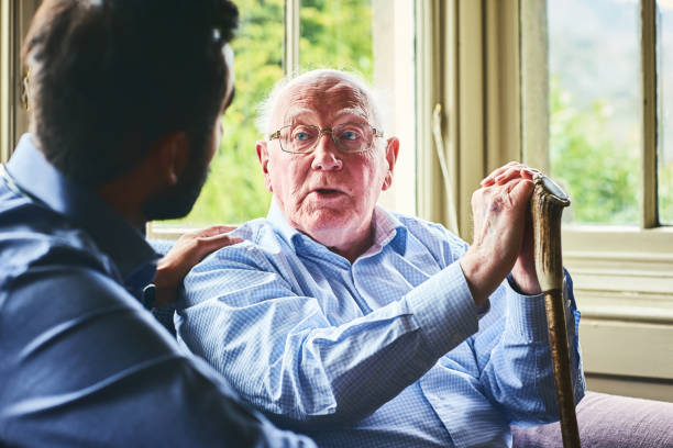 istock Elderly man talking with doctor at home 941321198