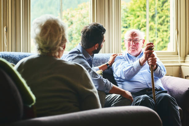 istock Senior man talking with medic in home visit 941321218