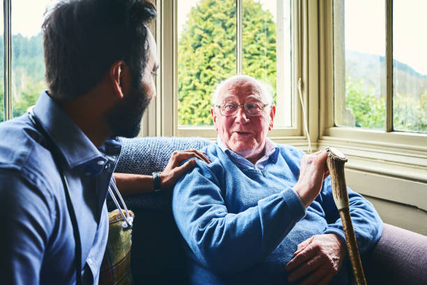 istock Doctor talking with senior man in home visit 941321234