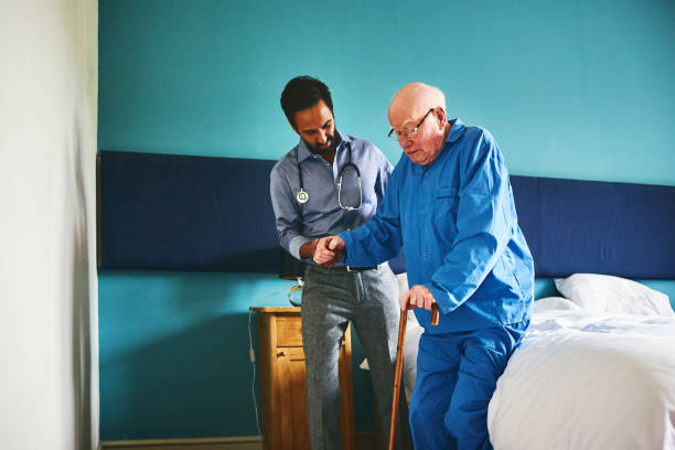 istock Doctor assisting elderly patient to walk 941321430