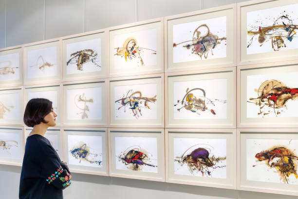 Newyork, USA - April 17, 2016: Appearence from NewYork ArtExpo 2016. artists are speaking to each other in front of the pictures and one man has a camera. International Artexpo is the world’s largest fine art trade show, providing dealers, collectors and buyers with access to thousands of innovative works from artists and publishers in one single venue.