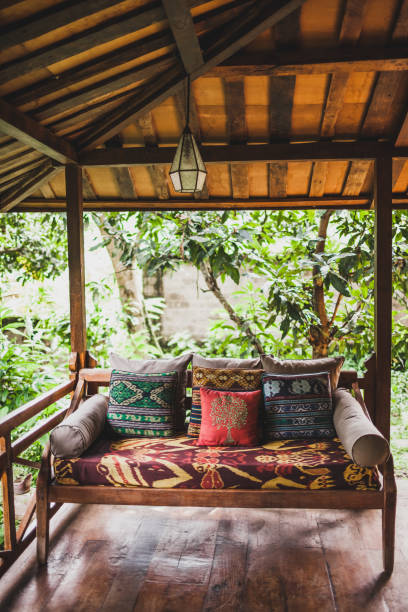 деревянный диван с подушками на террасе под крышей в этническом стиле с красочными традиционными орнаментами - nook стоковые фото и изображения