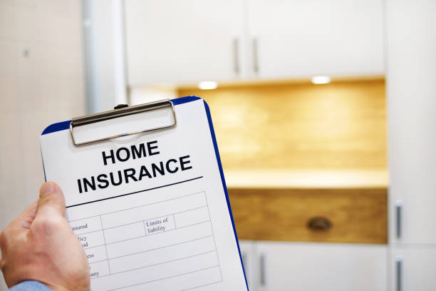 istock Hand holding clipboard with Home insurance form. 941328420