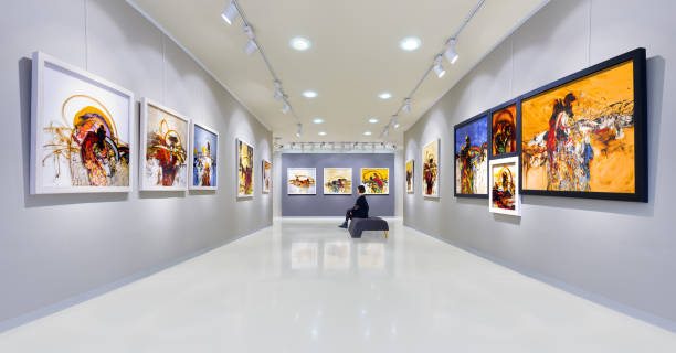 Artist's collection at showroom In a art gallery young woman visits an art exhibition and watches artist's collection. fine art painting photos stock pictures, royalty-free photos & images