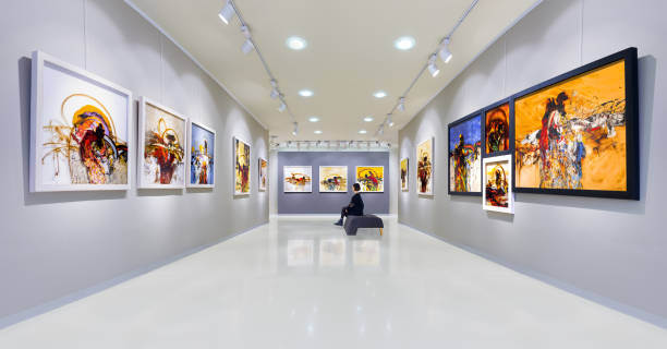 Artist's collection at showroom In a art gallery young woman visits an art exhibition and watches artist's collection. art and craft product stock pictures, royalty-free photos & images