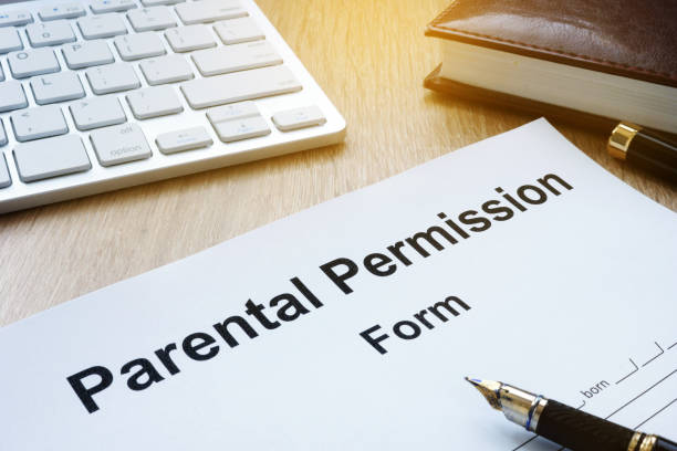 istock Parental Permission Form on a wooden table. 941329028