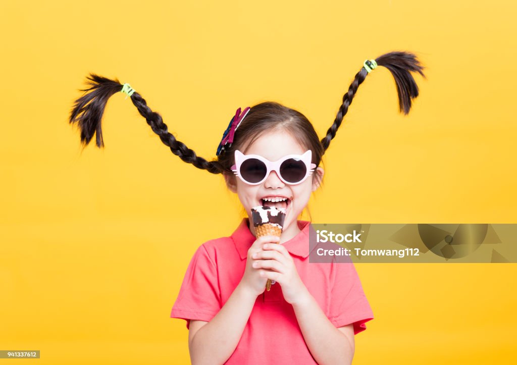 sonriente a niña comiendo helado - Foto de stock de Niño libre de derechos