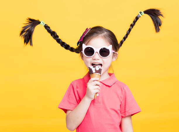 istock smiling little girl eating ice cream 941338376