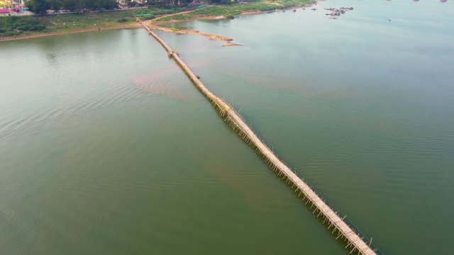 Aerial drone shot revealing a long bamboo bridge connect to the Asian Town