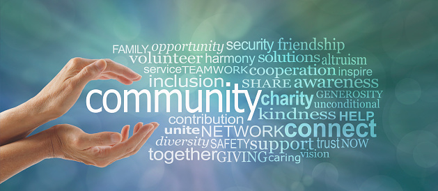 Female cupped hands around the word COMMUNITY and a relevant word tag cloud against a blue green bokeh background