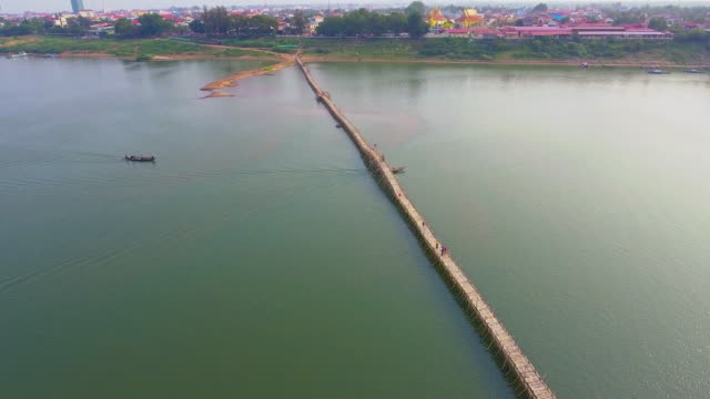 Aerial drone shot : slider shot of a long bamboo bridge over mekong river.