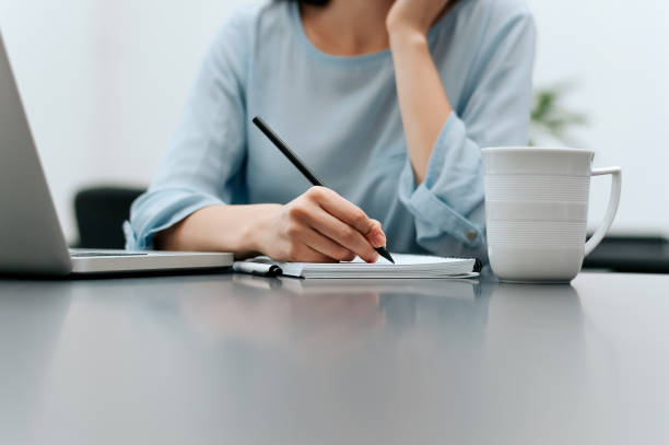 istock Close up of woman, taking notes in office. 941369358
