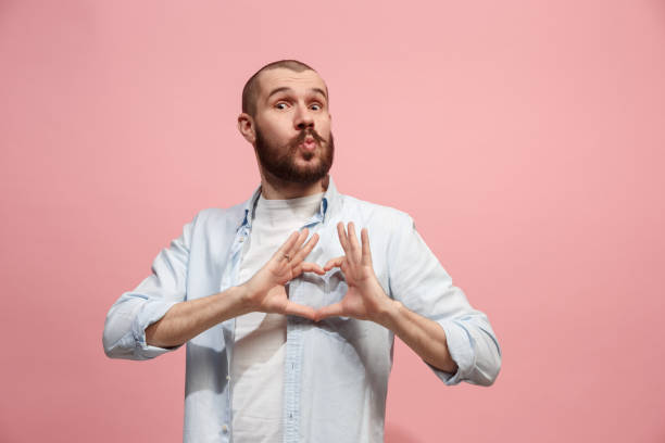 retrato de hombre atractivo con beso aislado sobre fondo rosa - blowing men kissing blowing a kiss fotografías e imágenes de stock