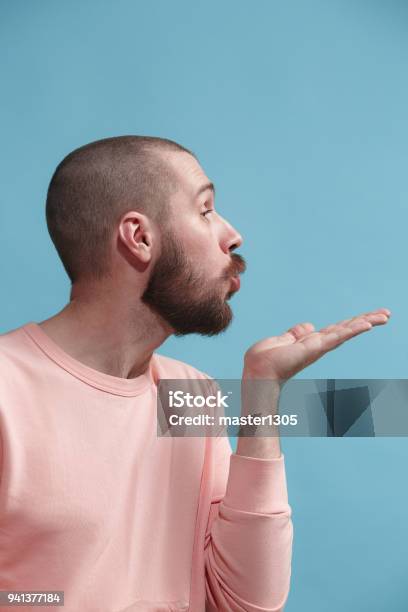 Isolated On Blue Young Casual Man Kissing At Studio Stock Photo - Download Image Now