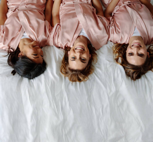 istock Three young women lying on bed and smiling 941381744