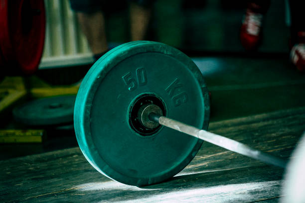 rod with green plates 50 kg for deadlift on wooden floor