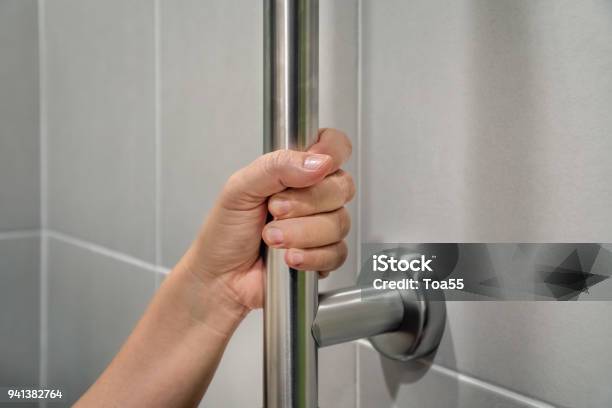 Woman Holding On Handrail In Toilet Stock Photo - Download Image Now - Security Bar, Gripping, Reaching