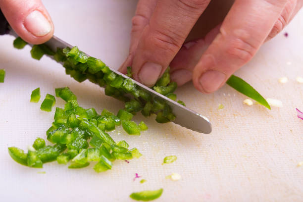 knife cuts green chilli pepper into small pieces