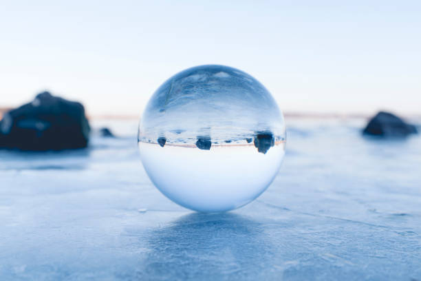 istock Glass orb balancing on ice on a frozen lake 941387876