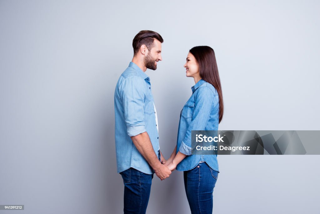 Concept of love. Two young happy people with beaming smile standing face-to-face and holding hands Face To Face Stock Photo