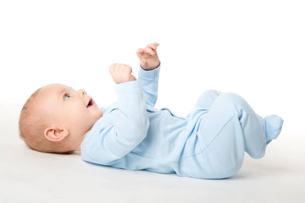 赤ちゃん幼児子供を着た青いボディー スーツ、白の子幸せの背中に横たわって - 仰向きに寝る ストックフォトと画像