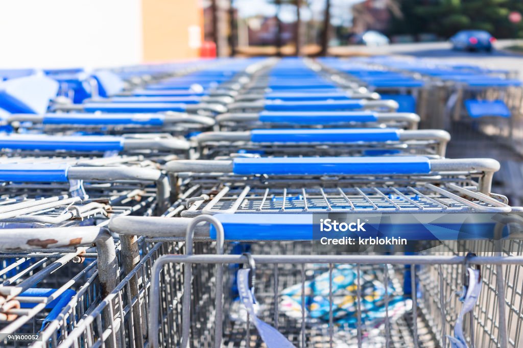 Many rows of blue shopping carts outside by store with closeup by parking lot Shopping Cart Stock Photo
