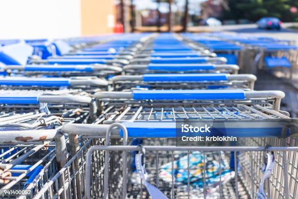 Many Rows Of Blue Shopping Carts Outside By Store With Closeup By Parking Lot Stock Photo - Download Image Now