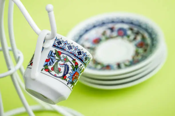 Coffee cups on a white hanger on green background