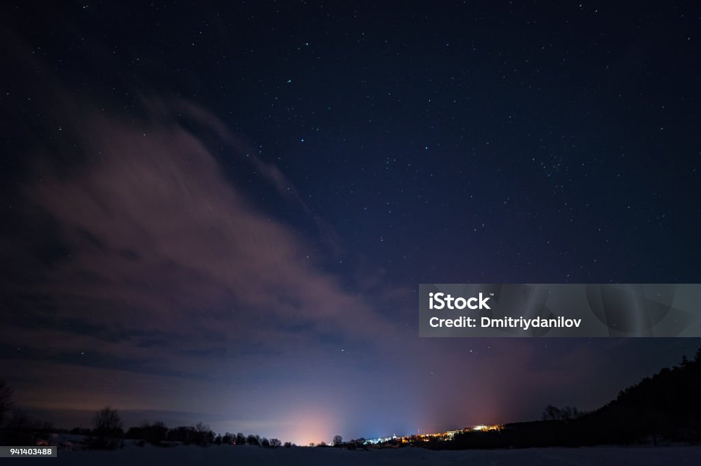 Starry sky with small clouds over the city in the distance Night Stock Photo
