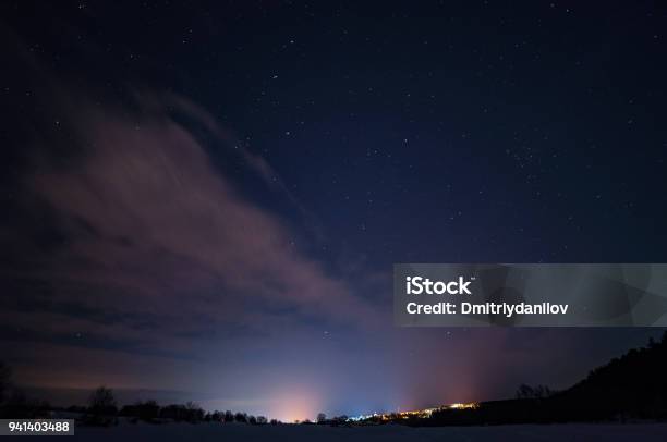 Starry Sky With Small Clouds Over The City In The Distance Stock Photo - Download Image Now