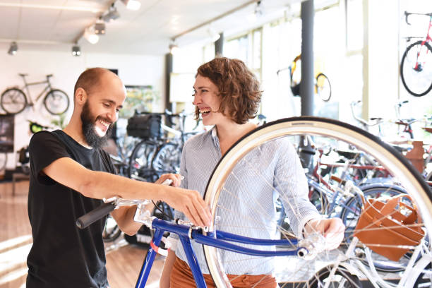 Bicycle shop consulting - salesman and customer in conversation Bicycle shop consulting - salesman and customer in conversation bicycle shop stock pictures, royalty-free photos & images