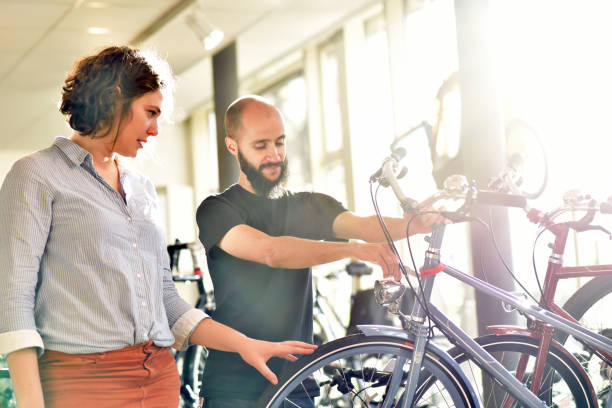 Bicycle shop consulting - salesman and customer in conversation Bicycle shop consulting - salesman and customer in conversation bicycle shop stock pictures, royalty-free photos & images