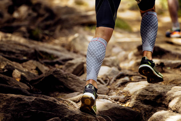 legs runner in compression calf sleeve legs runner in compression calf sleeve running uphill on rocks sleeve photos stock pictures, royalty-free photos & images