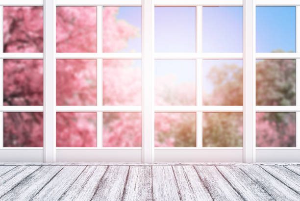 istock Room interior with window frame and wooden table in Shabby Chic style. Spring sunny day with pink sakura trees outside. 941410860